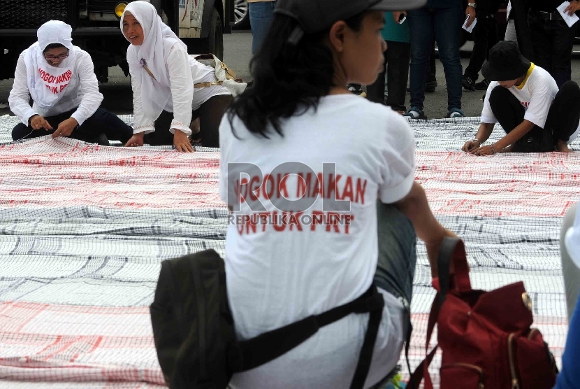 Massa buruh yang mengatasnamakan Jaringan Nasional Advokasi Pekerja Rumah Tangga (Jala PRT) menggelar serbet raksasa sebagai simbol perlawanan. saat aksi di depan Gedung DPR/MPR RI, Jakarta, Selasa (24/3). Republika/Agung Supriyanto