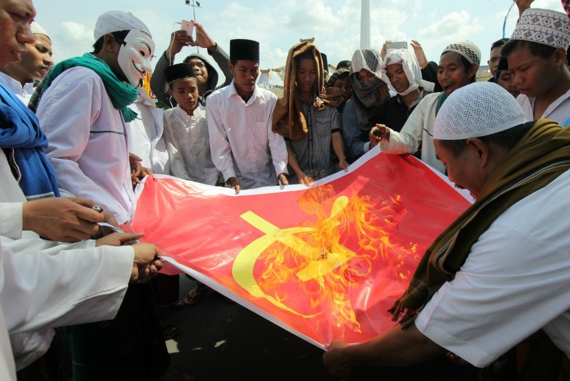 Massa dari Front Pembela Islam (FPI) dan Front Pancasila membakar kain bersimbol komunis di depan kantor Gubernur Jawa Timur, Surabaya, Jawa Timur.