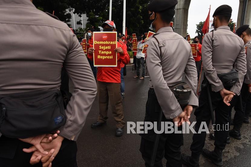 Massa dari Gerakan Buruh bersama Rakyat membawa poster saat berunjuk rasa di depan Mabes Polri, Jakarta, Jumat (6/11/2020). Dalam aksinya mereka menolak tindakan represif yang dilakukan oleh aparat kepolisian saat mengamankan aksi unjuk rasa penolakan pengesahan Omnibus Law UU Cipta Kerja di sejumlah daerah beberapa waktu lalu.