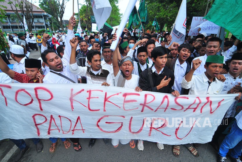 Massa dari PGRI, KAHMI, HMI dan siswa se Madura melakukan salat gaib untuk mendiang Ahmad Budi Cahyanto guru SMAN 1 Torjun yang tewas dianiaya siswanya saat aksi solidaritas Duka Budi Duka Kita di depan Polres Sampang, Jawa Timur, Sabtu (3/2). 
