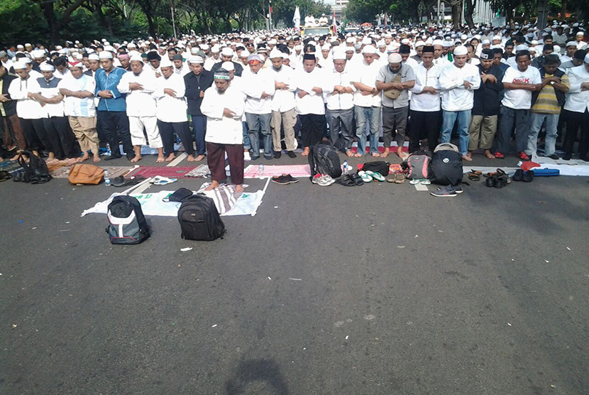 Massa demonstran gelar shalat Ashar di Jalan Merdeka Selatan, Jakarta Pusat, depan Balai Kota DKI Jakarta,  Jumat (4/11).