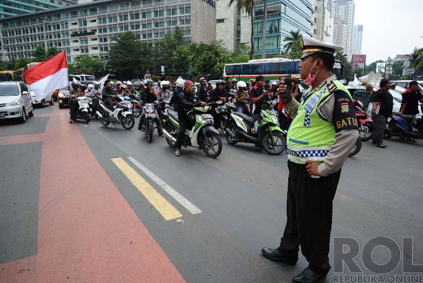  Massa Front Transportasi Jakarta menggelar aksi menolak perda pembatasan sepeda motor di kawasan Bundaran HI, Jakarta, Senin (22/12). (Republika/Tahta Aidilla)