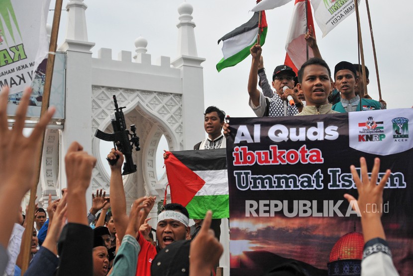 Massa gabungan Ormas Islam Aceh mengusung spanduk, poster dan bendera saat menggelar aksi solidaritas terhadap Palestina di kawasan Masjid Raya Baiturrahman, Banda Aceh, Jumat (8/12).