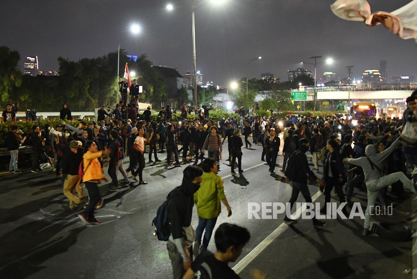 Massa mahasiswa memblokade Tol Dalam Kota saat berunjuk rasa menolak UU KPK dan pengesahan RUU KUHP di depan kompleks Parlemen di Jakarta, Senin (23/9/2019) malam.