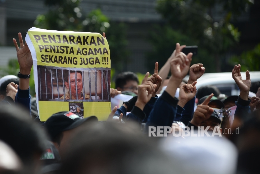 Massa melakukan aksi saat sidang perdana terdakwa penistaan agama, Basuki Tjahaja Purnama di Pengadilan Negeri Jakarta Utara, Selasa, (13/12).