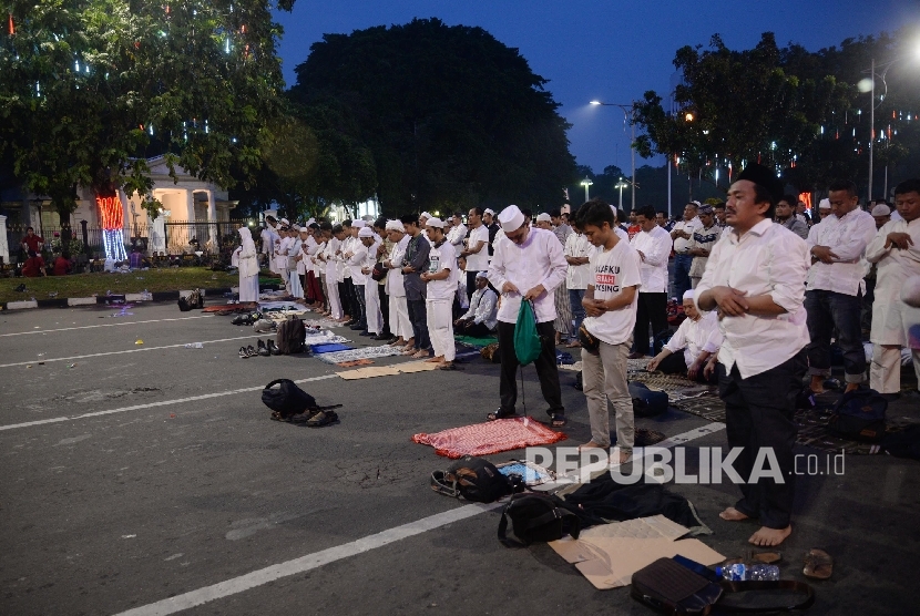 Massa melakukan shalat disela-sela demonstrasi di depan Istana Merdeka di Jakarta, Jumat (4/11)