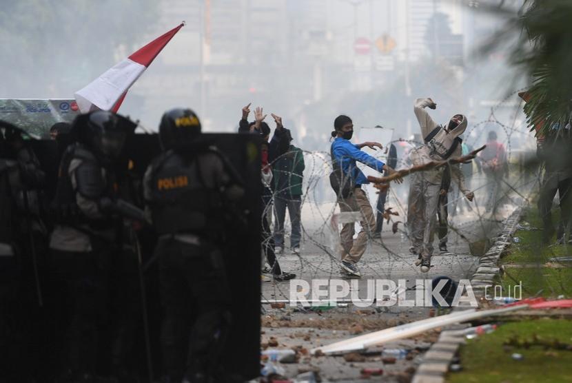 [Ilustrasi] Massa melemparkan batu saat bentrokan dengan polisi saat unjuk rasa menentang UU Cipta Kerja di Jakarta, Kamis (8/10/2020).