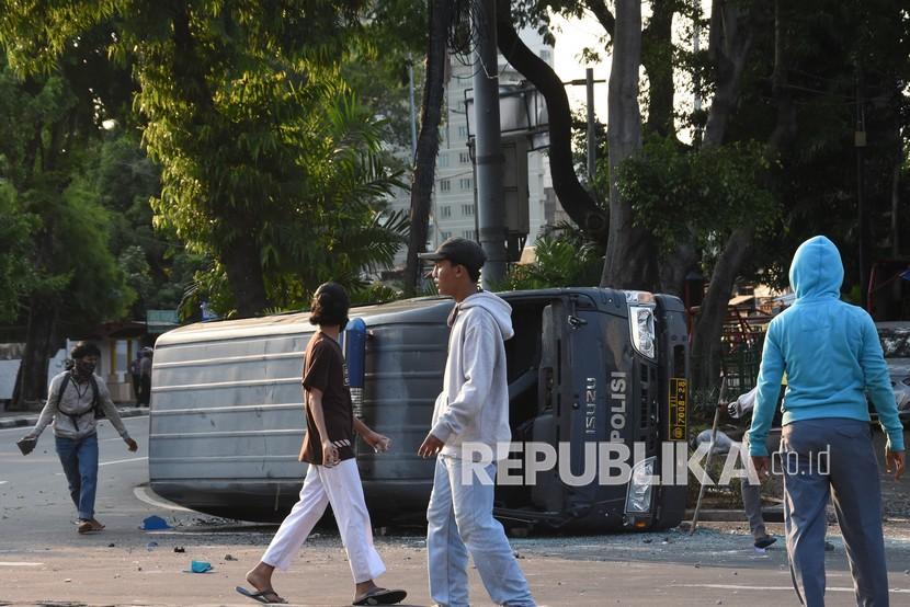 Massa menghancurkan mobil polisi di kawasan Penjernihan, Jakarta, Rabu (7/10/2020). Aksi massa tersebut sebagai bentuk penolakan atas disahkannya Omnibus Law UU Cipta Kerja oleh DPR pada Senin (5/10) lalu. 
