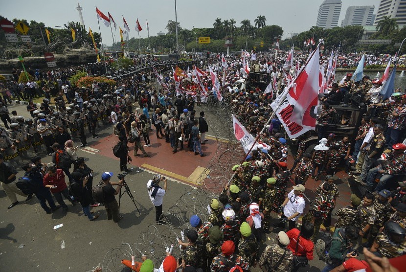 Massa pendukung pasangan capres dan cawapres Prabowo Subianto dan Hatta Rajasa saling berhadapan dengan polisi yang melakukan barikade di Jalan Medan Merdeka Barat, Jakarta, Kamis (21/8). 