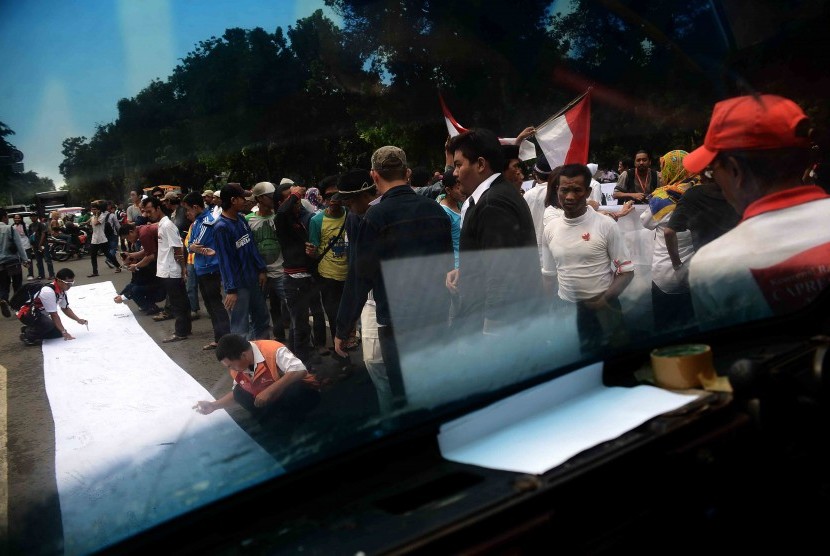 Massa pendukung Prabowo Subianto-Hatta Rajasa menandatangai kain putih saat berunjuk rasa di depan Gedung Mahkamah Konstitusi (MK), Jakarta Pusat, Jumat (25/7). 