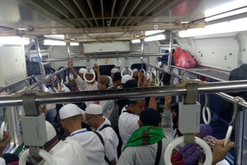 Massa peserta Aksi Bela Palestina dengan pakaian serba putih mendominasi penumpang Kereta Commuter Line atau KRL, Ahad (17/12). 