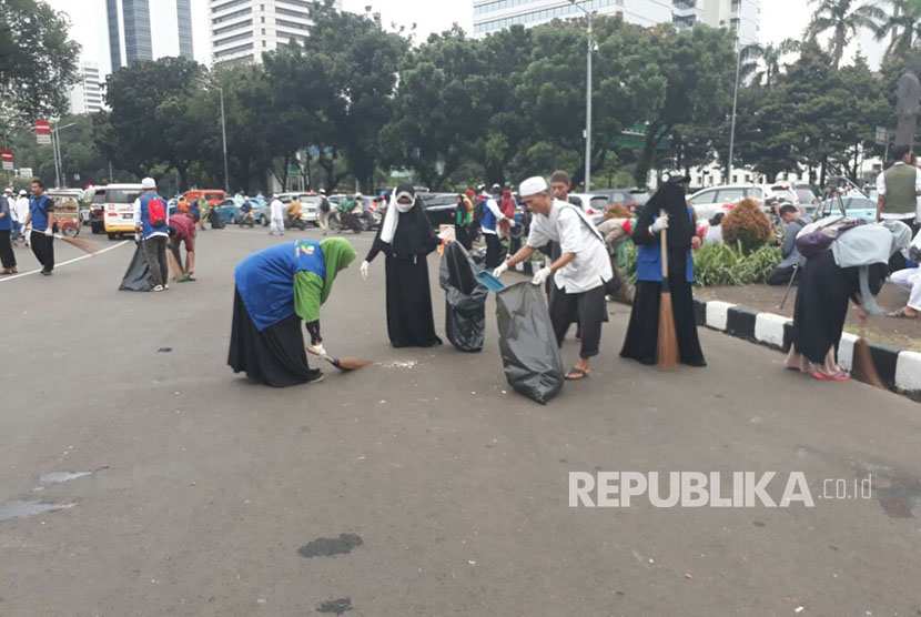 Massa peserta aksi,  membersihkan sampah pasca-aksi 313 di Jalan Medan Merdeka Barat , Jumat (31/3).