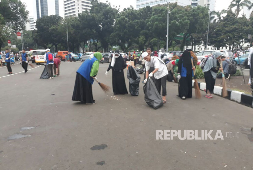 Massa peserta aksi membersihkan sampah pascaaksi 313 di Jalan Medan Merdeka Barat , Jumat (31/3).