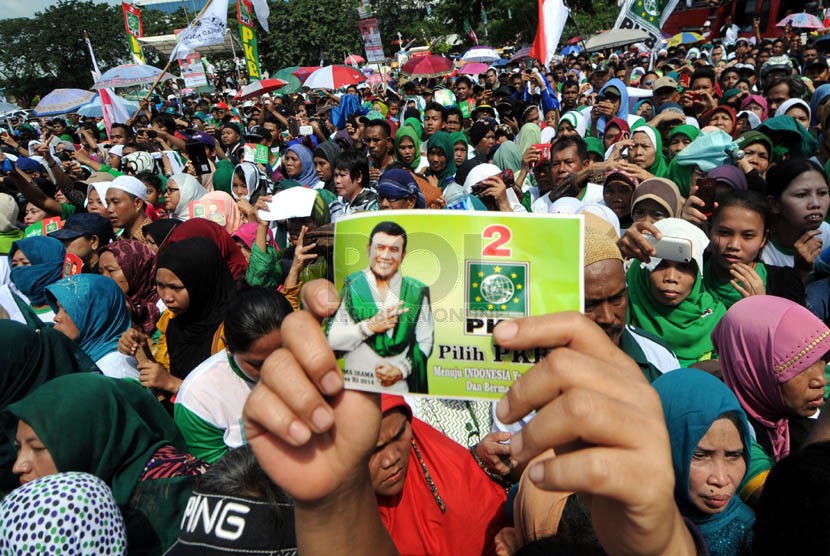   Massa simpatisan Partai Kebangkitan Bangsa (PKB) memegang stiker Rhoma Irama saat mengikuti kampanye terbuka di Pulo Mas, Jakarta, Senin (24/3). (Republika/Aditya Pradana Putra)
