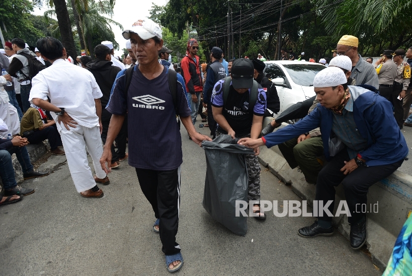 Massa yang tergabung dalam GNPF MUI memungut sampah saat melakukan aksi kawal sidang ahok.