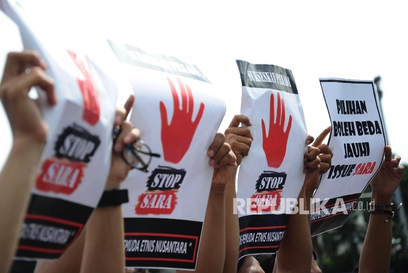 Massa yang tergabung dalam Lintas Pemuda Etnis Nusantara membawa poster saat aksi kampanye di Bundaran HI, Jakarta, Ahad (9/10).