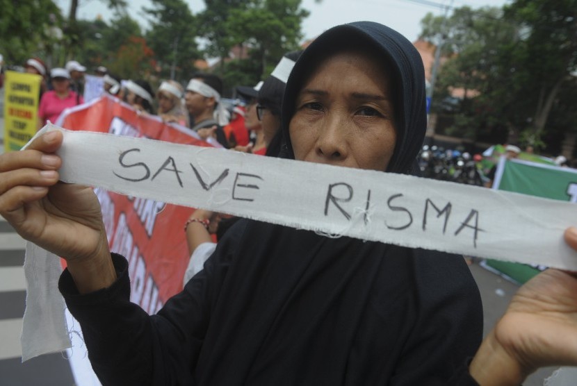 Massa yang tergabung dalam Suara Arek Surabaya membentangkan poster saat aksi menolak Risma dicalonkan dalam Pilgub Jatim di depan Balai Kota Surabaya, Jawa Timur, Senin (8/1). 