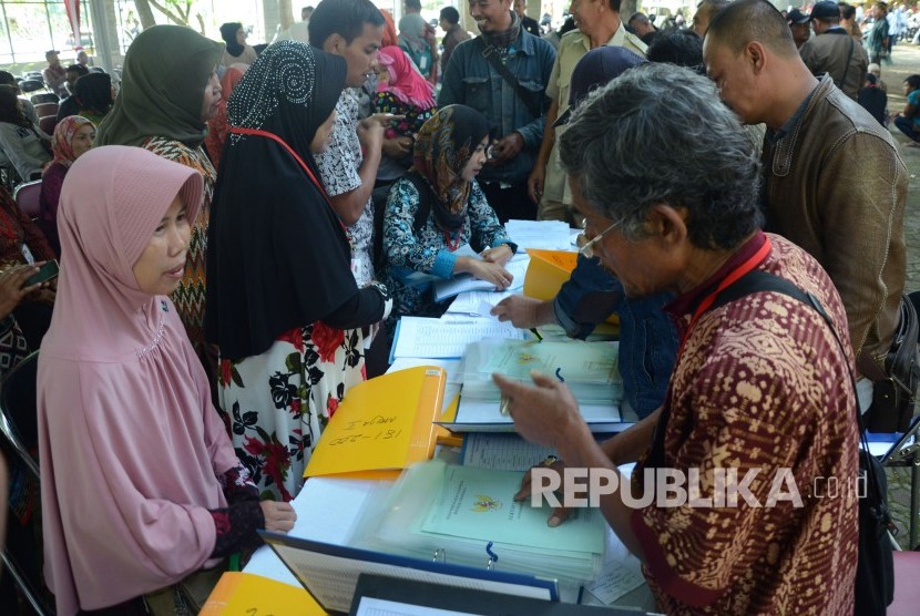 Masyarakat antre mengambil sertifikat tanah pada pembagian 10 ribu sertifikat tanah di kantor Pemkab Badung, Soreang, Kabupaten Bandung, Senin (4/12).