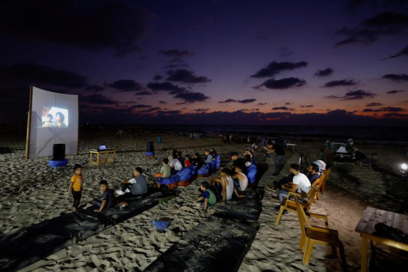 Warga Gaza, Palestina melihat layar tancap di pantai, merindukan kembali bioskop yang 30 tahun lebih tutup.