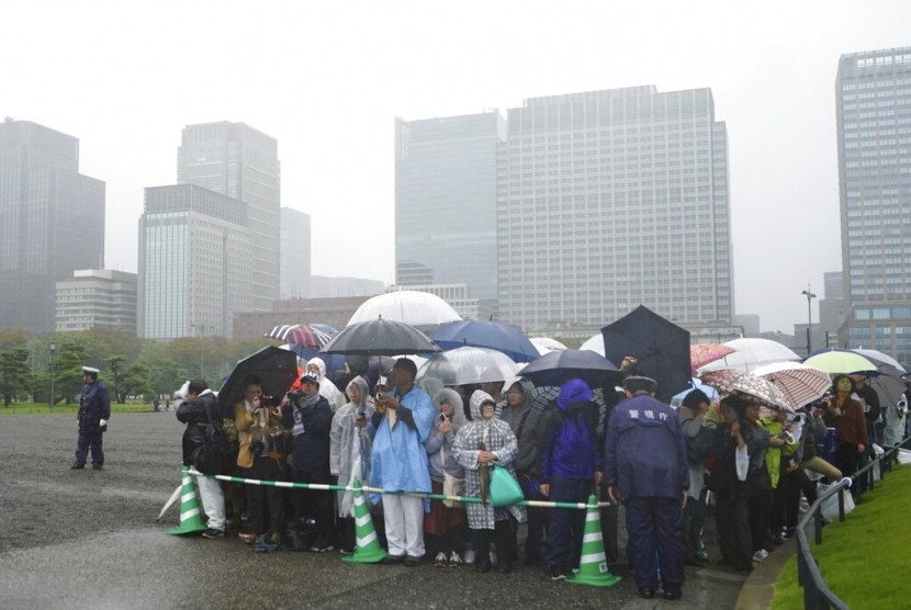 Masyarakat Jepang berbaris dan menunggu di luar istana Imperial Palace sebelum upacara penobatan kaisar Naruhito, Selasa (22/10).