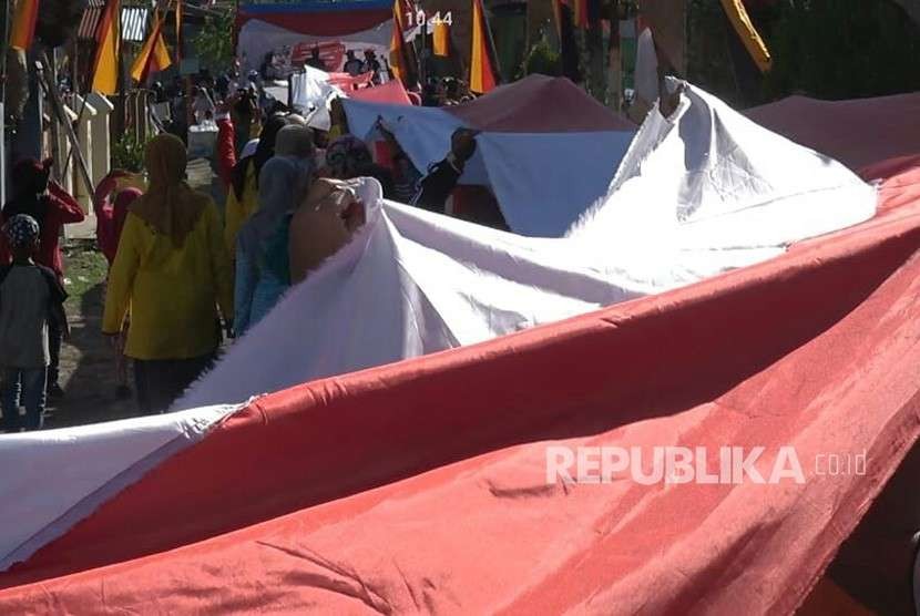 Masyarakat Kota Padang membentangkan bendera merah putih sepanjang 1 km, Ahad (19/8). Kegiatan ini dilakukan untuk memeriahkan peringatan HUT ke-73 kemerdekaan RI. 