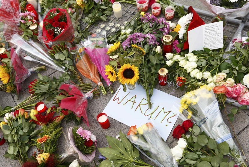 Masyarakat meletakkan karangan bunga tanda simpati terhadap korban penembakan di dekat pusat perbelanjaan di Muenchen, Jerman.