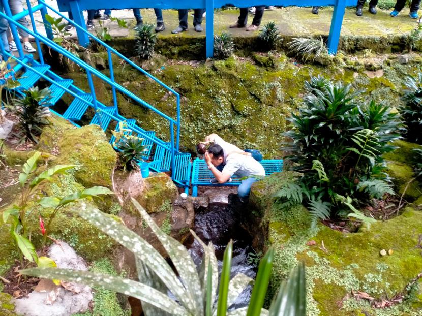 Masyarakat membasuh wajah dengan menggunakan air di titik nol Kali Brantas, Arboretum Sumber Brantas,  Bumiaji, Kota Batu. 
