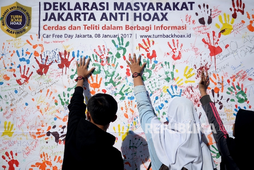 Masyarakat membubuhkan cap tangan saat kegiatan sosialisasi sekaligus deklarasi masyarakat anti hoax di Jakarta,Ahad (8/1).