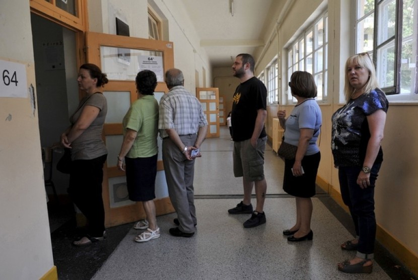 Masyarakat mengantre untuk memberikan suaranya dalam jajak pendapat di Thessaloniki, Ahad (5/7). Jajak pendapat meminta pertimbangan warga Yunani untuk menerima atau tidak bantuan asing bagi ekonomi Yunani.