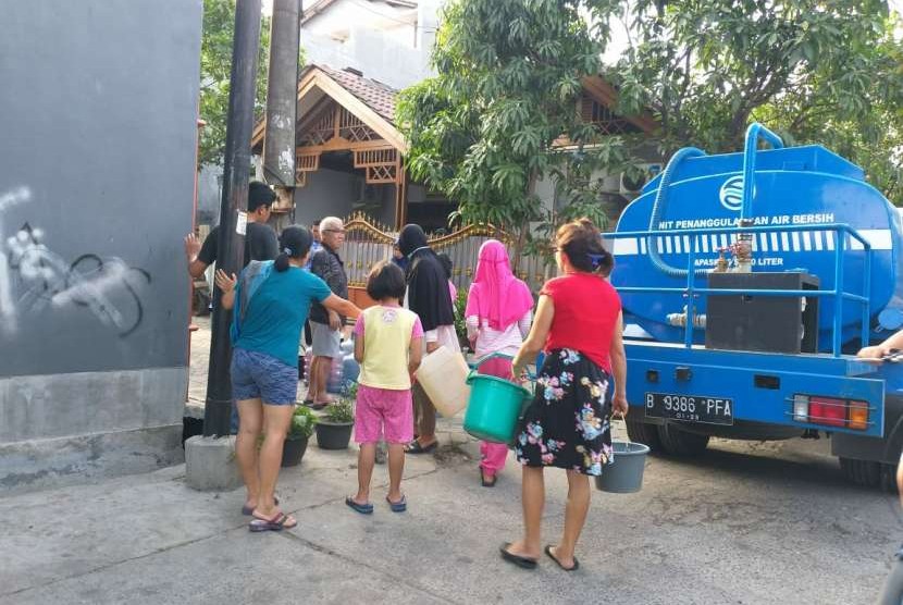 Masyarakat mengerubungi truk tangki air bersih.