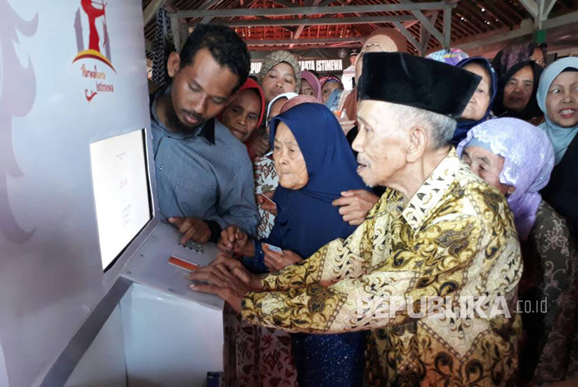 Masyarakat miskin  sedang mencoba fasilitas mesin ATM beras (Ilustrasi)