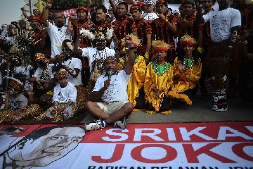 Masyarakat Papua mengenakan pakaian aadat menggelar aksi sebagai dukungannya terhadap Jokowi di Bundaran HI, Jakarta, Ahad (18/5). 