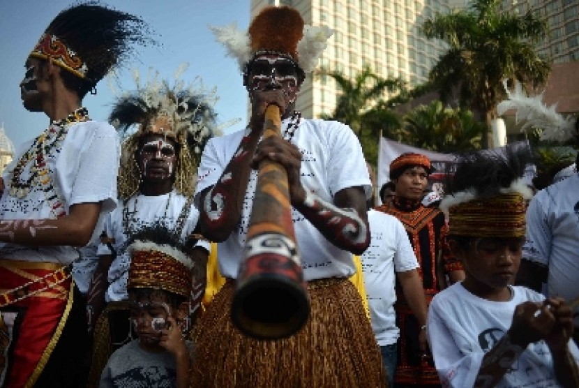 Masyarakat Papua mengenakan pakaian aadat menggelar aksi sebagai dukungannya terhadap Jokowi di Bundaran HI, Jakarta, Ahad (18/5). 