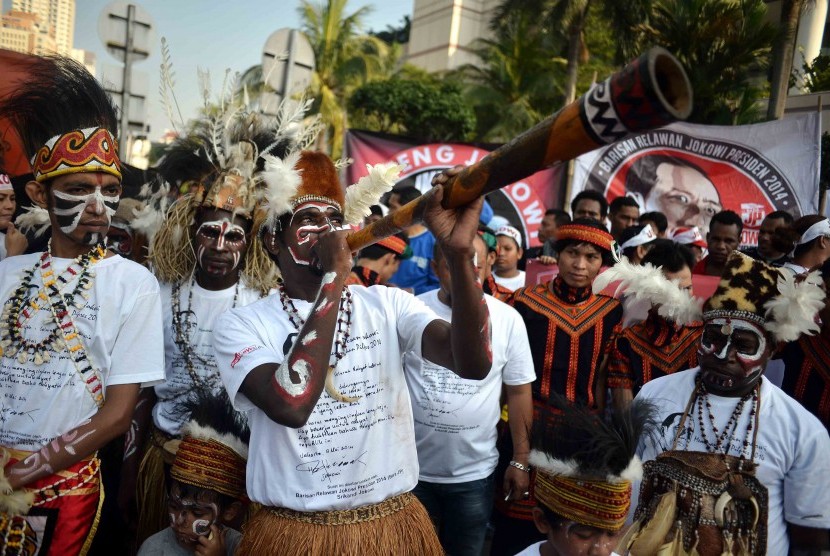 Masyarakat Papua mengenakan pakaian aadat menggelar aksi sebagai dukungannya terhadap Jokowi di Bundaran HI, Jakarta, Ahad (18/5). 