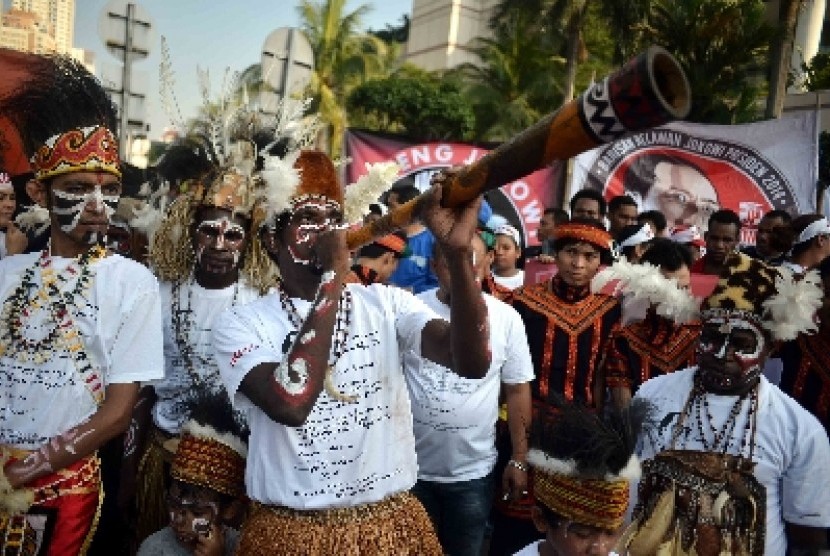 Masyarakat Papua mengenakan pakaian adat menggelar aksi sebagai dukungannya terhadap Jokowi di Bundaran HI, Jakarta, Ahad (18/5). 