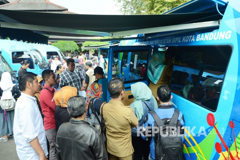 Masyarakat termasuk di antaranya mahasiswa ITB antre saat pelayanan perekaman KTP elektronik cepat di sejumlah mobil Dinas Kependudukan dan Catatan Sipil (Disdukcapil) Kota Bandung di halaman kampus ITB, Senin (26/2).