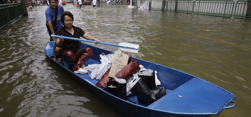 Masyarakat Thailand berdagang dengan menggunakan perahu di tengah kota Bangkok, Jumat, 28/10. (AP)