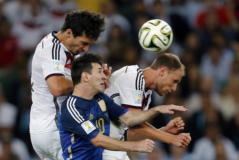 Mats Hummels (kiri), Lionel Messi (tengah), dan Benedikt Hoewedes berebut bola