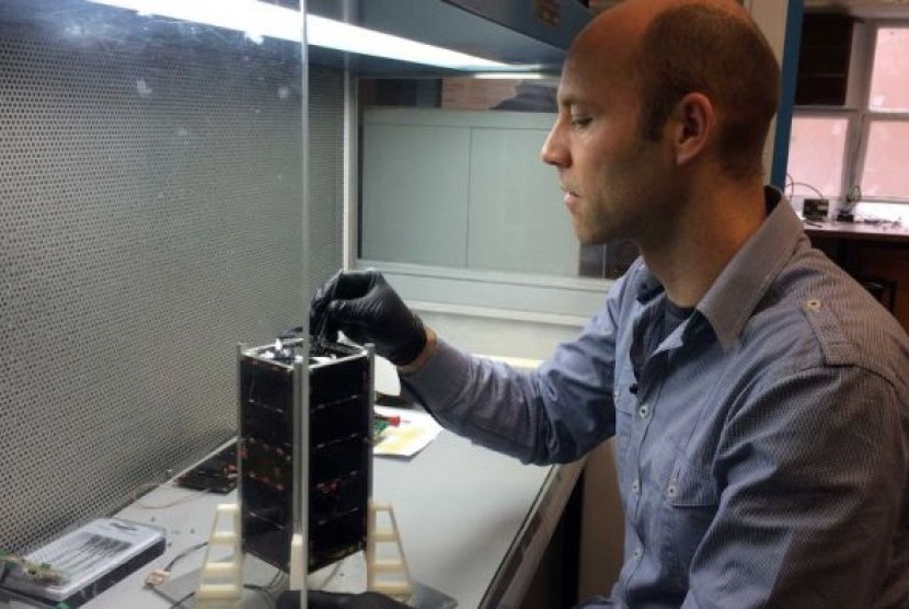 Matt Tetlow mengerjakan proyek satelit di laboratorium.