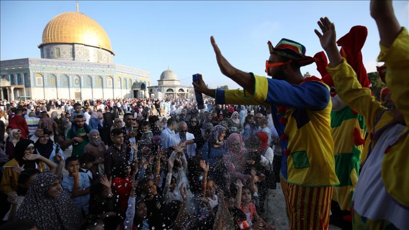 Mayarakat Palestina sedang menikmati hiburan badut di dekat Mesjid ai-Aqsa.