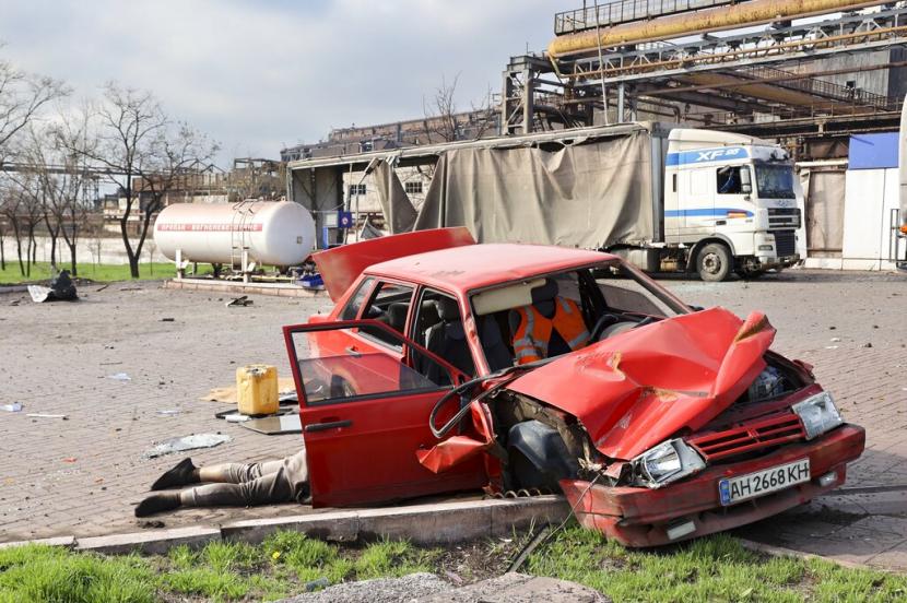 Mayat seorang warga sipil tergeletak di sebelah mobil yang rusak di dekat Pabrik Metalurgi Illich Iron & Steel Works, perusahaan metalurgi terbesar kedua di Ukraina, di daerah yang dikendalikan oleh pasukan separatis yang didukung Rusia di Mariupol, Ukraina, Sabtu, 16 April 2022.