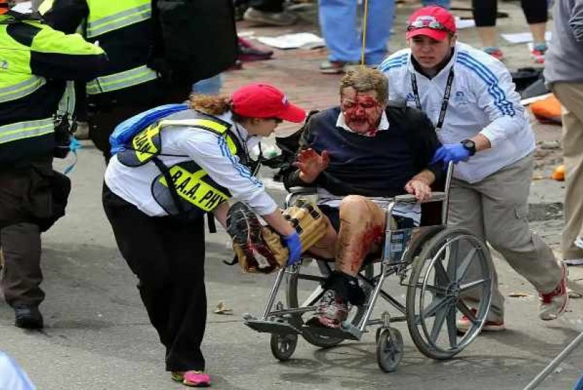   Medical workers aid an injured man at the 2013 Boston Marathon following an explosion in Boston, Monday, April 15, 2013