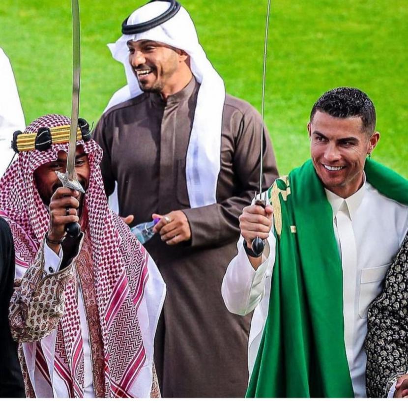 Mega bintang sepak bola dunia yang kini memperkuat klub Liga Arab Saudi Al Nassr, Cristiano Ronaldo (kanan) kembali mengundang perhatian. Sosok berusia 38 tahun ini berpakaian islami dengan gamis dan sorban hijau yang terkalung di lehernya. 