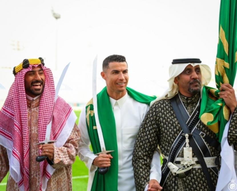 Megabintang sepak bola asal Portugal, Cristiano Ronaldo (tengah), bersama rekan setimnya di klub Al Nassr turut merayakan Hari Berdirinya Arab Saudi yang kedua kalinya. Pemain berjuluk CR7 ini bahkan mengenakan pakaian tradisional Arab Saudi sambil menari Ardha. Ronaldo mengucapkan selama bulan suci Ramadhan kepada seluruh umat Islam di dunia pada Rabu (22/3/2023). 