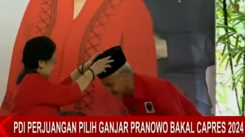Megawati Soekarnoputri memasangkan kopiah ke Ganjar Pranowo. Megawati sebut Ganjar Pranowo sebagai capres PDIP tetap petugas partai dan menuruti.