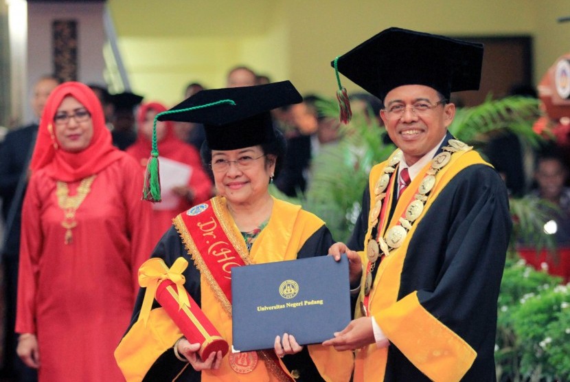 Megawati Soekarnoputri (tengah) menerima piagam Doktor yang diberikan Rektor Universitas Negeri Padang Ganefri (kanan) saat penganugerahan gelar Doktor Honoriis Causa Bidang Politik Pendidikan, di auditorium Universitas Negeri Padang (UNP), Sumatera Barat, Rabu (27/9). 