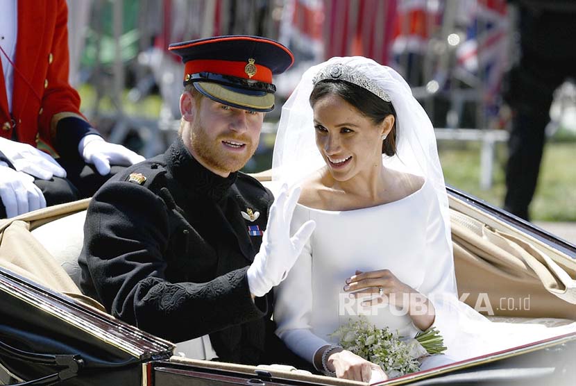 Meghan Markle  bersama Pangeran Harry menaiki kerea kuda setelah upacara pernikahan mereka di Kapel Istana Windsor, di Windsor, Inggris, Sabtu (19/5) waktu setempat.