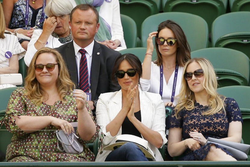 Meghan Markle (tengah) bertepuk tangan memberi dukungan pada petenis Serena Williams yang bertanding di laga Wimbledon, Kamis (4/7), di London, Inggris.