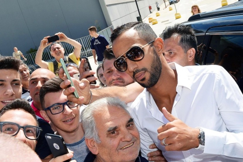 Mehdi Benatia (kanan) berfoto dengan fan Juventus.