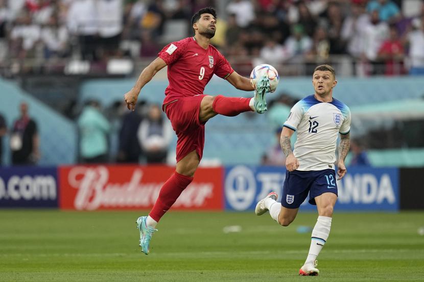  Mehdi Taremi dari Iran (kiri) mencoba untuk mengontrol bola selama pertandingan sepak bola grup B Piala Dunia antara Inggris dan Iran di Stadion Internasional Khalifa di Doha, Qatar, Senin, 21 November 2022. 